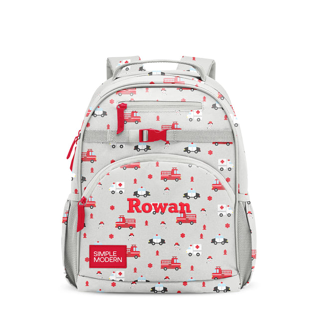 Simple Modern Rowan children's backpack with emergency vehicle print featuring red fire trucks, police cars, and fire hydrants on light gray base, multiple zippered pockets, padded straps, front-facing on white background. Simple Modern Rowan children's backpack with emergency vehicle print featuring red fire trucks, police cars, and fire hydrants on light gray base, multiple zippered pockets, padded straps, front-facing on white background.