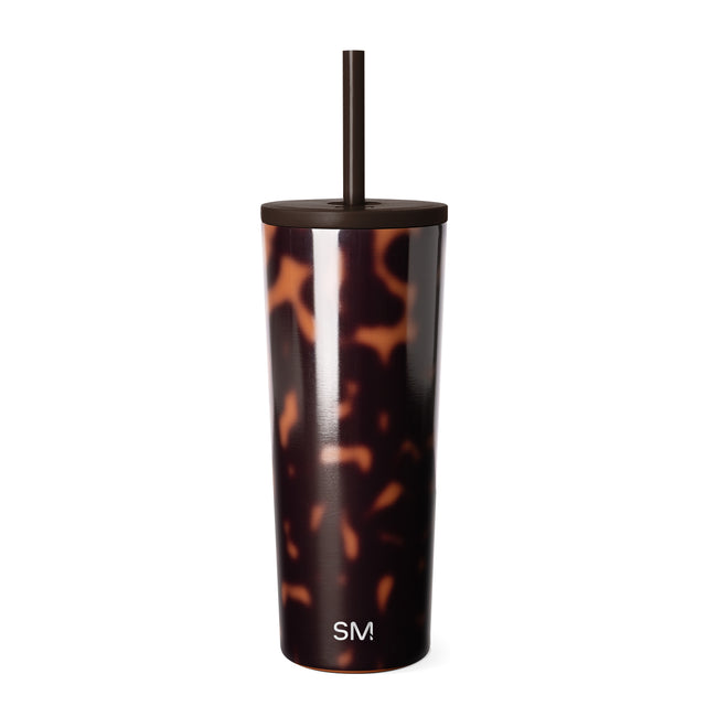 Tortoiseshell patterned tumbler with amber, orange, and tan tones over charcoal base, featuring black matte lid and straw, Simple Modern logo visible, photographed against white background. Tortoiseshell patterned tumbler with amber, orange, and tan tones over charcoal base, featuring black matte lid and straw, Simple Modern logo visible, photographed against white background.