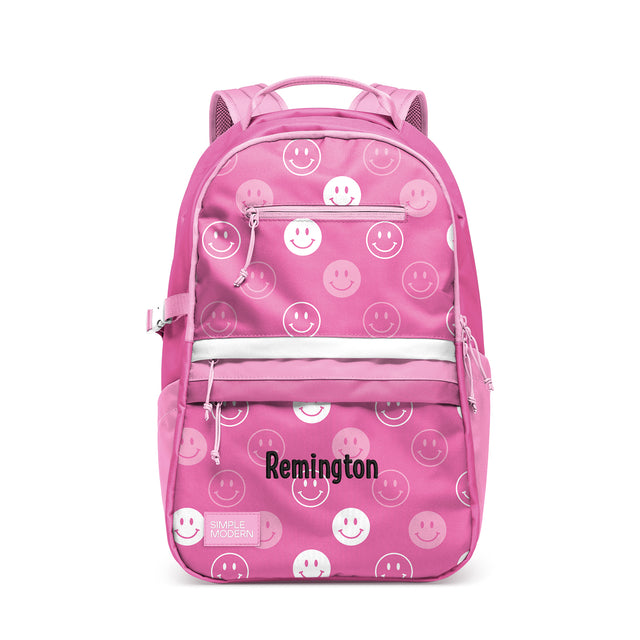 Hot pink children's backpack with white smiley face pattern, padded straps, front zippered pockets, white horizontal stripe, and mesh ventilation panels. Remington by Simple Modern brand. Hot pink children's backpack with white smiley face pattern, padded straps, front zippered pockets, white horizontal stripe, and mesh ventilation panels. Remington by Simple Modern brand.