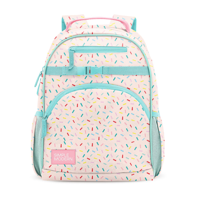 Pastel pink children's backpack with turquoise trim, colorful confetti dashes, three zippered compartments, side mesh pockets, turquoise handles, and Simple Modern label, photographed front-facing on white background. Pastel pink children's backpack with turquoise trim, colorful confetti dashes, three zippered compartments, side mesh pockets, turquoise handles, and Simple Modern label, photographed front-facing on white background.