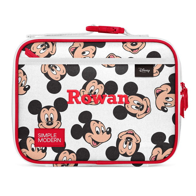 White insulated lunch box with red accents, featuring repeating Mickey Mouse character faces, red handle and zippers, mesh panel at bottom. Simple Modern brand and Rowan label visible. Disney merchandise product shot. White insulated lunch box with red accents, featuring repeating Mickey Mouse character faces, red handle and zippers, mesh panel at bottom. Simple Modern brand and Rowan label visible. Disney merchandise product shot.