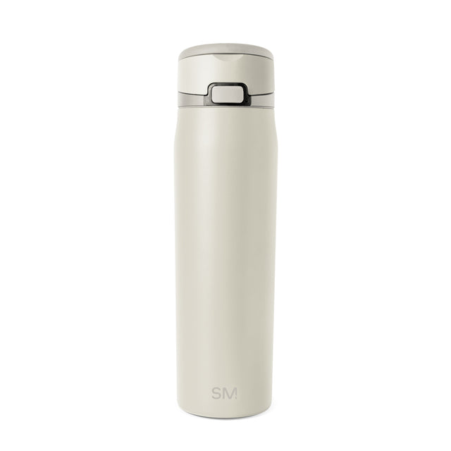 Cream-colored bottle with dark gray accents on neutral beige background Cream-colored bottle with dark gray accents on neutral beige background
