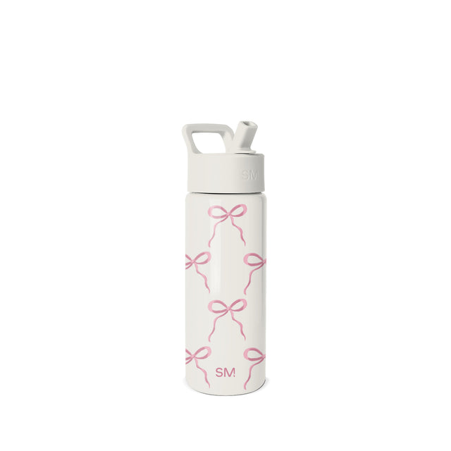 White and pink Simple Modern water bottle with straw cap, carry handle, and repeating bow pattern design. SM logo on cap and body. Studio product photo on neutral background. White and pink Simple Modern water bottle with straw cap, carry handle, and repeating bow pattern design. SM logo on cap and body. Studio product photo on neutral background.