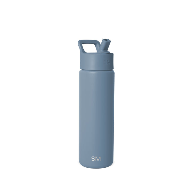 Slate blue insulated water bottle with flip-top lid and carrying handle against a white background. Simple Modern branded design with minimalist aesthetic. Slate blue insulated water bottle with flip-top lid and carrying handle against a white background. Simple Modern branded design with minimalist aesthetic.