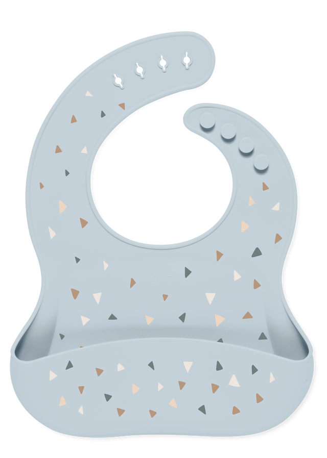 Light blue-gray baby bib with decorative triangular accents in tan, beige, caramel brown, and charcoal gray. Light blue-gray baby bib with decorative triangular accents in tan, beige, caramel brown, and charcoal gray.
