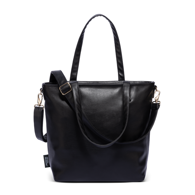 Black vegan leather Harper Tote with gold hardware, dual shoulder straps, and adjustable crossbody strap with buckle detail, shown against white background Black vegan leather Harper Tote with gold hardware, dual shoulder straps, and adjustable crossbody strap with buckle detail, shown against white background