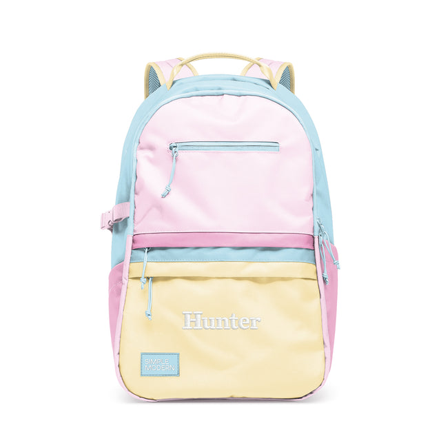 Pastel color-block backpack with horizontal bands of pink, blue, and yellow, featuring multiple zippered pockets, 