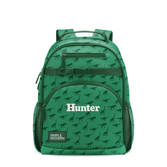 Kelly green children's backpack with dinosaur pattern, padded straps, front zippered pocket labeled 