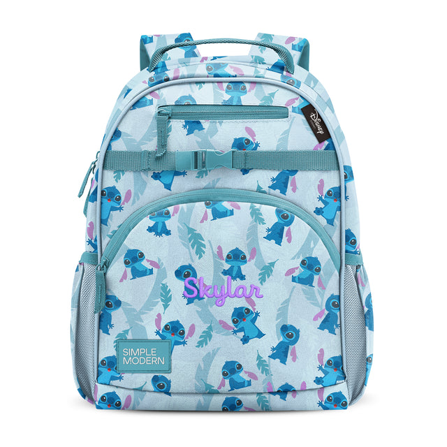 Children's backpack in pale blue with teal, navy, purple-pink, and mint green pattern. Features front pocket with 