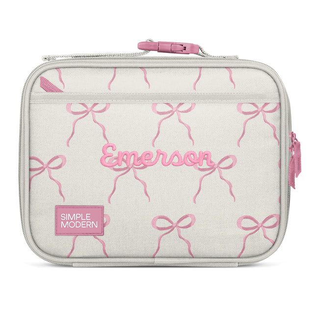 Soft gray-beige insulated lunch bag with pink embroidered bows, pink handle, and personalization reading 