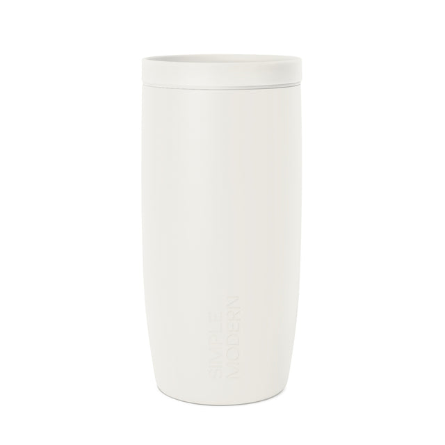 Cream-colored cylindrical travel mug with tapered design and embossed SM logo, shown against white background in studio product photography.