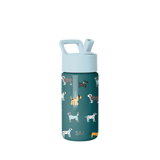 Deep teal Simple Modern kids water bottle with light blue lid and carrying handle, featuring repeating dog illustrations in white, cream, black, and yellow. SM logo visible on lid and body.