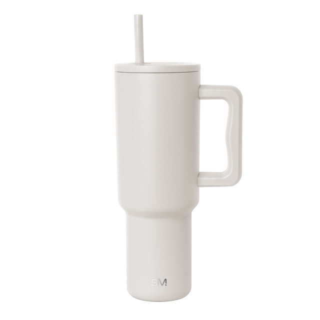 Cream-colored insulated tumbler with handle and matching lid featuring a centered straw. Simple Modern logo embossed on lower front. Cylindrical design with wider top tapering to narrow base on white background.
