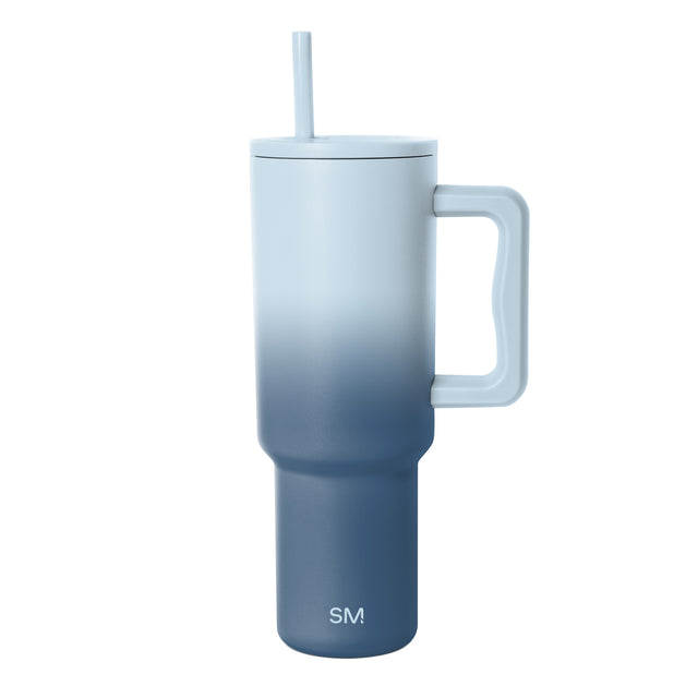Blue gradient insulated tumbler with handle and matching straw, featuring light blue upper section transitioning to navy blue base with Simple Modern logo, shown against white background.